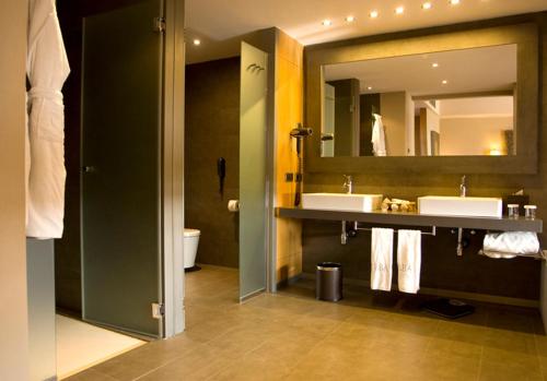 a bathroom with two sinks and a large mirror at Lopesan Baobab Resort in Meloneras