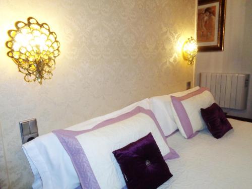 a bedroom with a bed with white and purple pillows at Hotel Boutique Nueve Leyendas in Úbeda