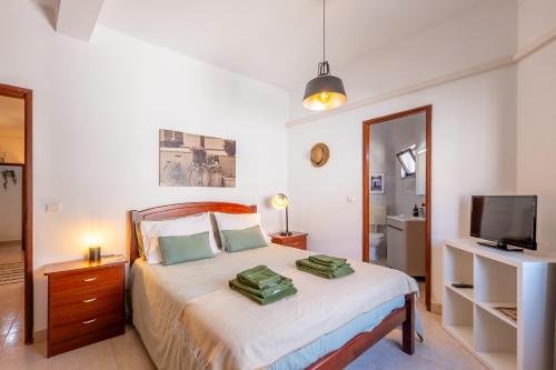 a bedroom with a bed with two pillows on it at Hospedaria Portuguesa in Alpiarça