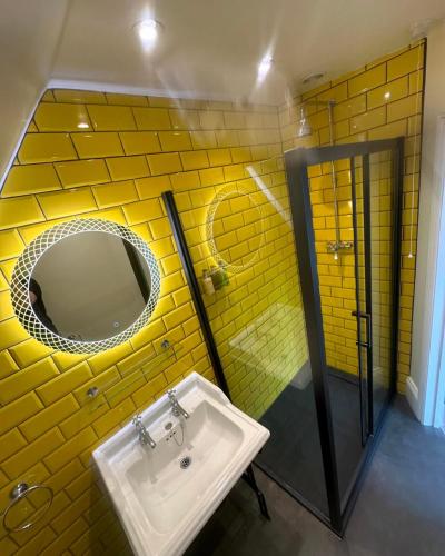 a yellow bathroom with a sink and a mirror at No4 Cromer in Cromer