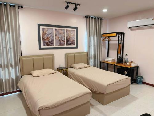 a bedroom with two beds and a mirror at NICHA Cafe' & Resort in Ban Thap Chek Ha