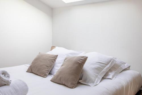 a white bed with four pillows on it at Le Chalet Panoramique Jaccuzi Parking Vue Montagne in Munster