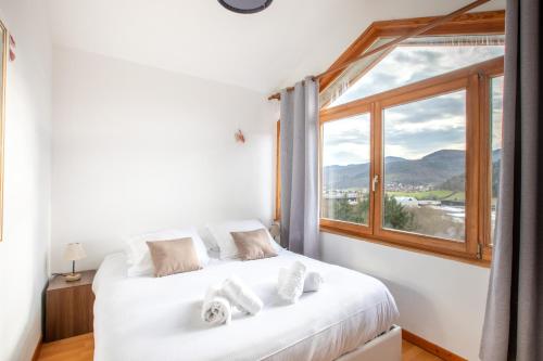 a bedroom with a bed and a large window at Le Chalet Panoramique Jaccuzi Parking Vue Montagne in Munster
