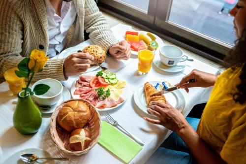 a group of people sitting at a table eating food at Europäischer Hof in Munich
