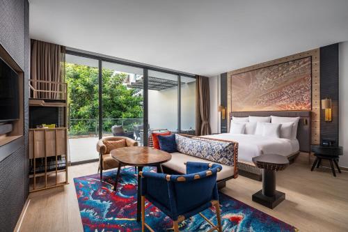 a hotel room with a bed and a living room at Hotel Indigo Phuket Patong by IHG in Patong Beach