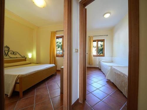 a bedroom with two beds and two windows at Residence Villaggio Smedile in Capo Vaticano