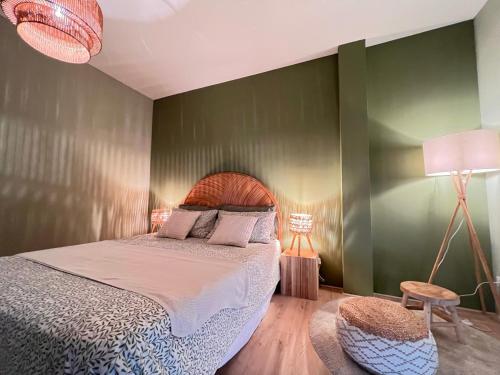 a bedroom with a bed and a green wall at Chianti's Secret Nest - Cozy home with sunset view in Impruneta