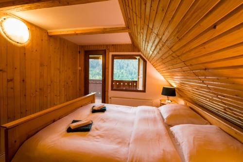 a bedroom with a large bed with a wooden ceiling at Chalet M 1 in Lunca Bradului