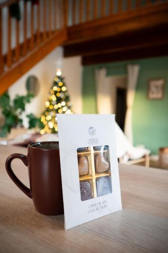 a cup of coffee and a box of chocolates at Burbujas de amor - gîte avec spa et sauna privatifs in Loubès-Bernac