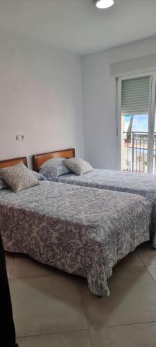 a bedroom with two beds and a window at Habitación Doble a 100 m de la Playa in Benidorm