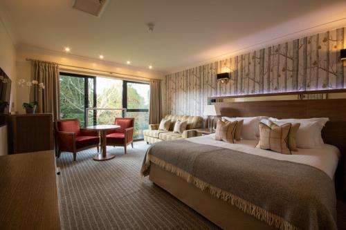 a hotel room with a bed and a living room at Careys Manor Hotel & SenSpa in Brockenhurst