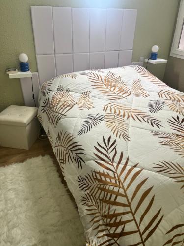 Un dormitorio con una cama con una manta blanca y marrón. en Cocon mirevalais, en Mireval