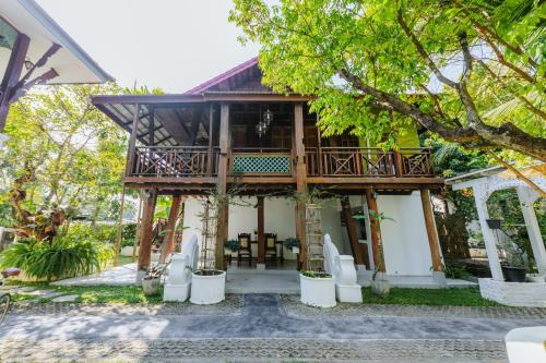 a house with a deck and chairs in front of it at Teewana Resort Chiang Mai in Chiang Mai