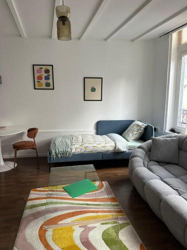 a living room with a couch and a rug at Appartements Cosy, Centre de Rosendaël, HomyNest in Dunkerque