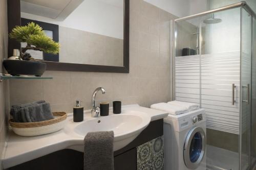 a bathroom with a sink and a washing machine at Stylish Tel Aviv in Tel Aviv