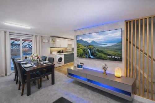 a living room with a dining table and a large painting on the wall at Skye View Cottage in Portree