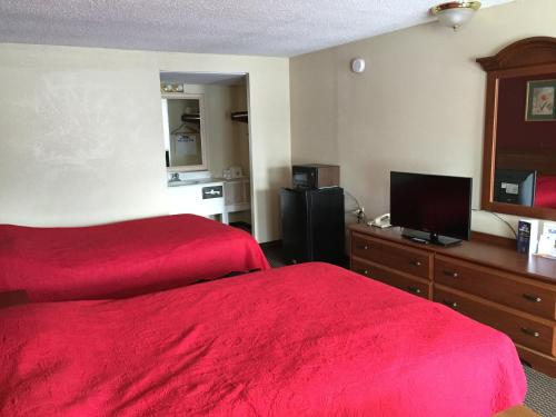 a hotel room with two beds and a flat screen tv at FairBridge Inn Express Merrillville in Merrillville