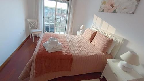 a bedroom with a large bed with two white towels on it at Lousã's Brown & White in Lousã