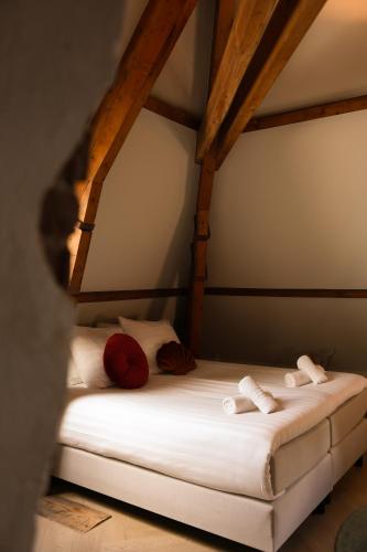 a bed with red and white pillows in a room at Boetiek hotel bij Jacob in Enschede