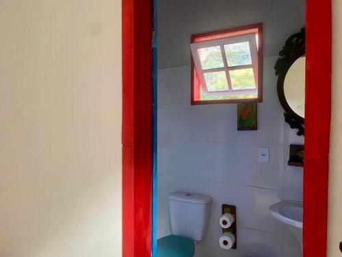 a small bathroom with a toilet and a window at Chalé na floresta com varanda in Ouro Preto