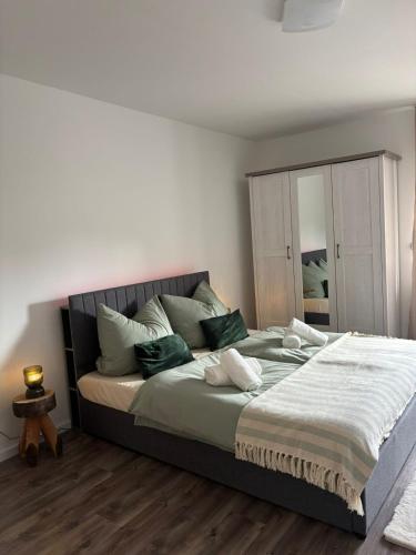 a bedroom with a large bed with green pillows at Viktoria Apartment in Speicher