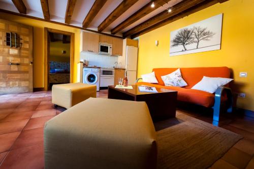 a living room with an orange couch and a table at Villa Don Juan II in Segovia
