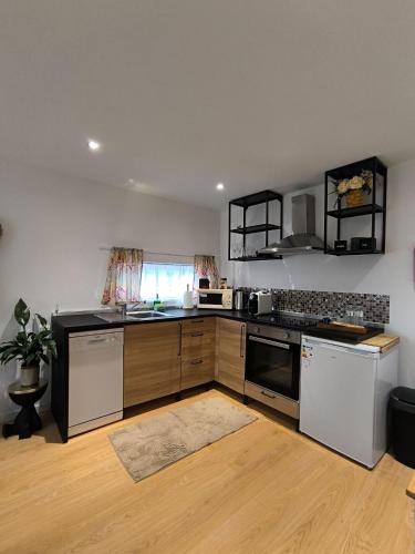 a kitchen with white appliances and wooden cabinets at Casa do Bento - Charming Cozy Loft, Vila do Conde in Fajozes
