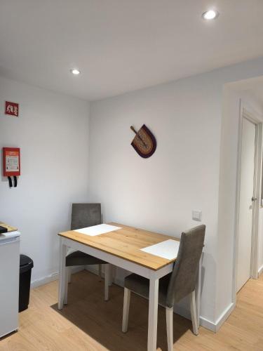 a dining room table with two chairs and a clock on the wall at Casa do Bento - Charming Cozy Loft, Vila do Conde in Fajozes