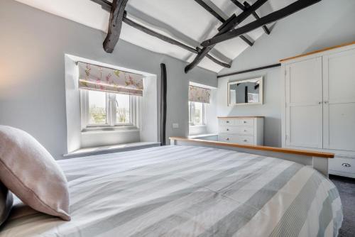 a bedroom with a large bed and two windows at 2 Bed in Bush oc-s31846 in Bude