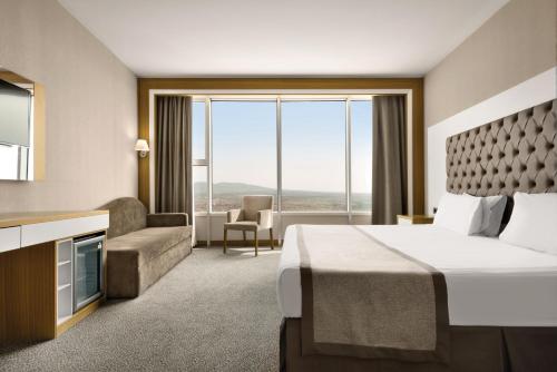 a hotel room with a bed and a television at BİG THERMAL Spa Resort in Kalankaldı