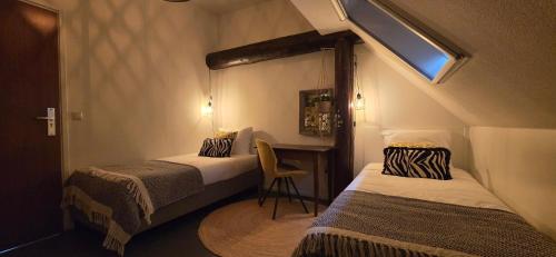 a small room with two beds and a desk at B&B Grolloo in Grolloo
