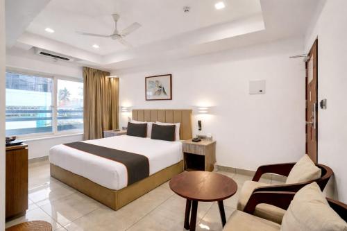 a hotel room with a bed and a couch at Soorya in Attingal