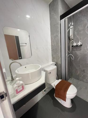 a bathroom with a toilet and a sink and a shower at SiLin Hotel in Ban Nong Pling
