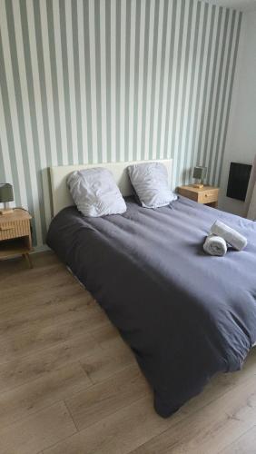 a bed with two pillows on top of it at L'ALPETTE maison 3 pièces 2 chambres tout confort in Vernouillet