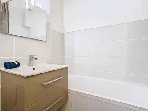 a bathroom with a sink and a bath tub at Le Pianiste in Voiron