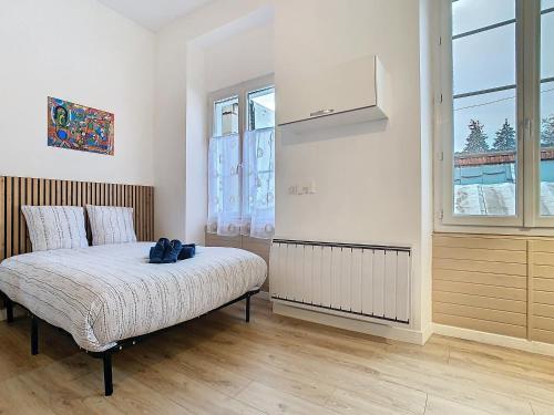 a bedroom with a bed and a large window at Le Pianiste in Voiron