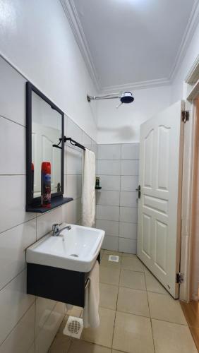 a white bathroom with a sink and a mirror at Kamakis Motel & Lounge in Ruiru
