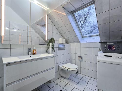 a bathroom with a toilet and a sink and a window at Alpha Apartments in Datteln