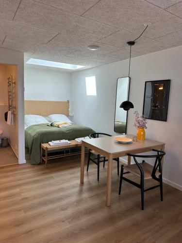 a bedroom with a bed and a table and a table sidx sidx sidx at HYGGE Strand Camping in Odder
