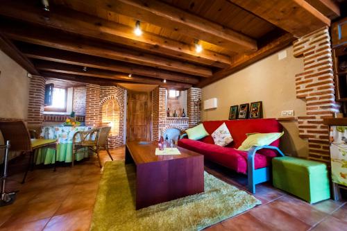 a living room with a red couch and a table at Villa Don Juan II in Segovia