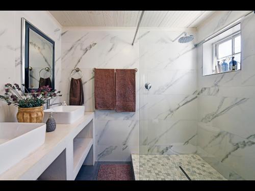 a white bathroom with a sink and a shower at Sunflower Villa in Franschhoek in Franschhoek