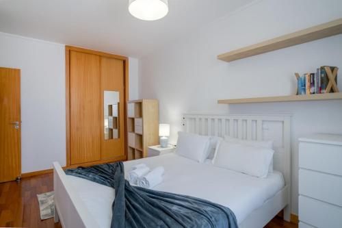 a bedroom with a white bed and a wooden door at Sea Side Cozy Matosinhos in Matosinhos