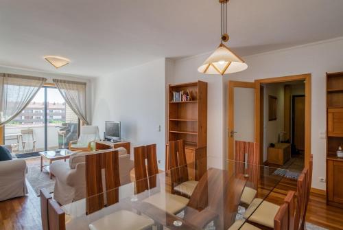 a dining room and living room with a glass table at Sea Side Cozy Matosinhos in Matosinhos