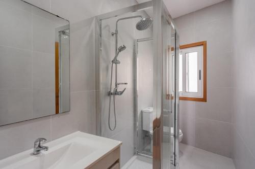a bathroom with a shower with a sink and a shower at Modern studio near Metro in Senhora da Hora
