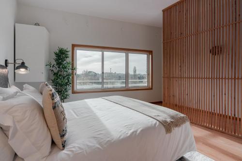 a bedroom with a large bed and a window at Modern studio near Metro in Senhora da Hora