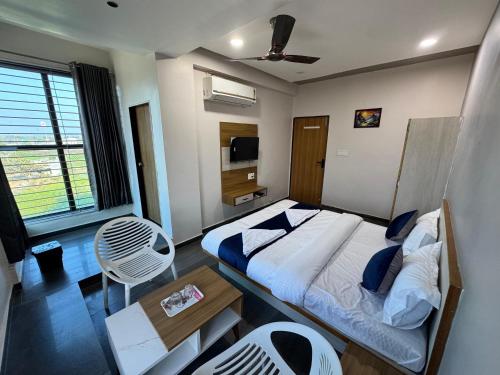 a bedroom with a bed and a table and a chair at Hotel Jb Classic in Himatnagar
