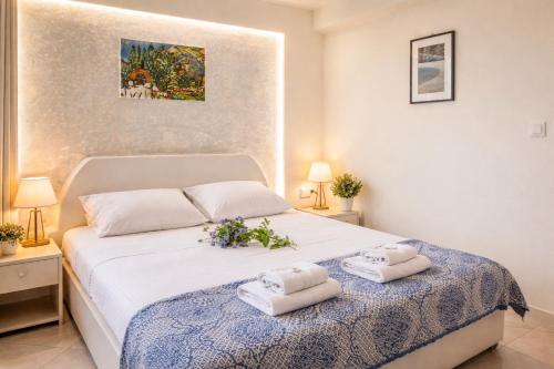a bedroom with a white bed with towels on it at Sea View Studios & Apartments in Agia Anna Naxos