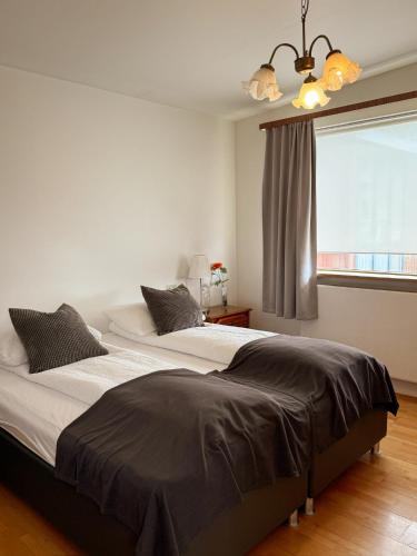 two beds in a bedroom with a window at BSG Apartments in Selfoss