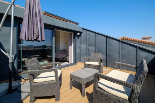 a patio with chairs and an umbrella on a balcony at Casa da Perafita /Matosinhos, 2 Km from the beach in Perafita
