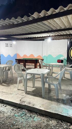 a group of white tables and chairs in front of a wall at Prive Dona Valentina in Itamaracá